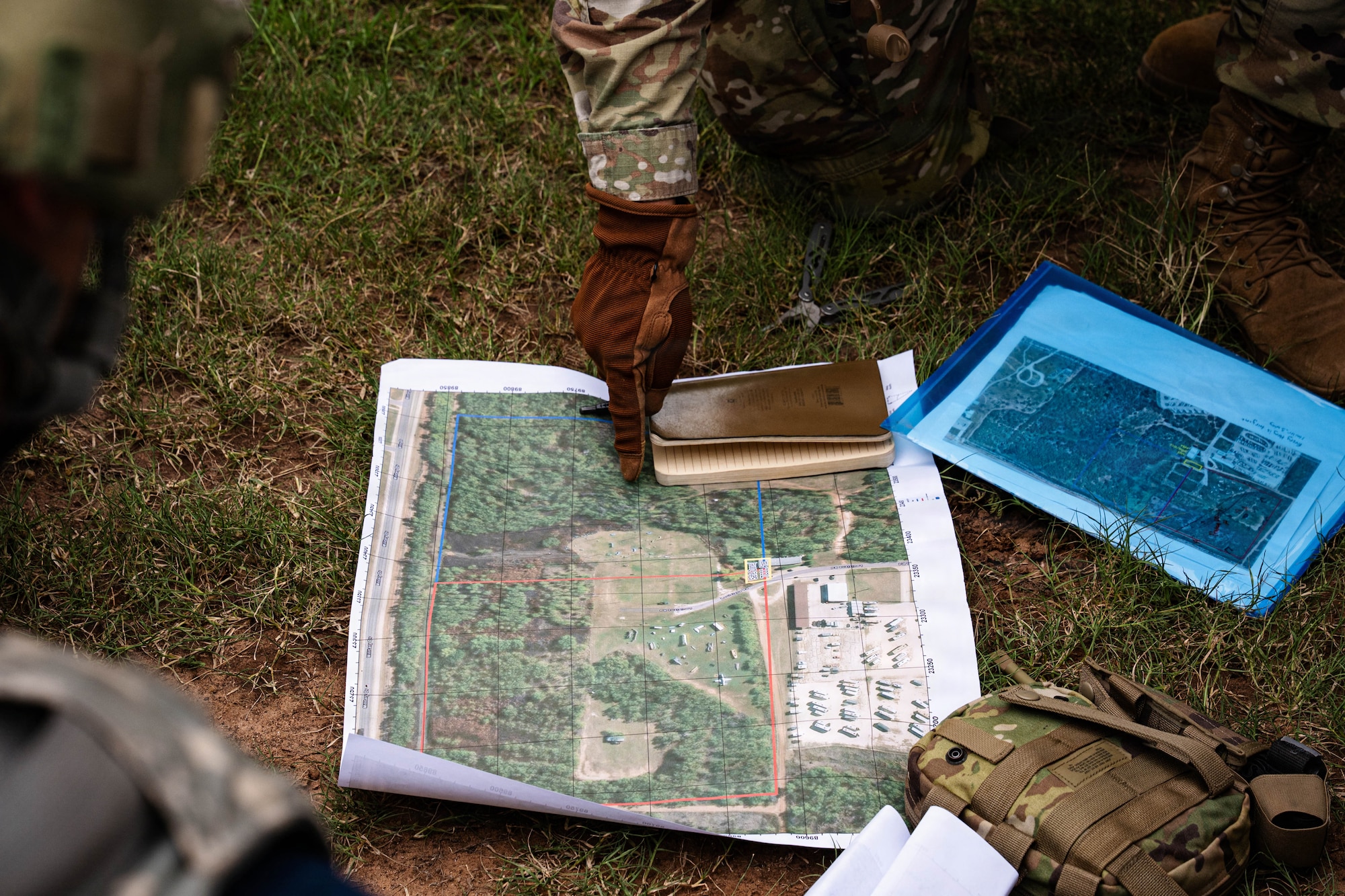 Airmen participate in a field exercise and play capture the flag outside in a wooded area