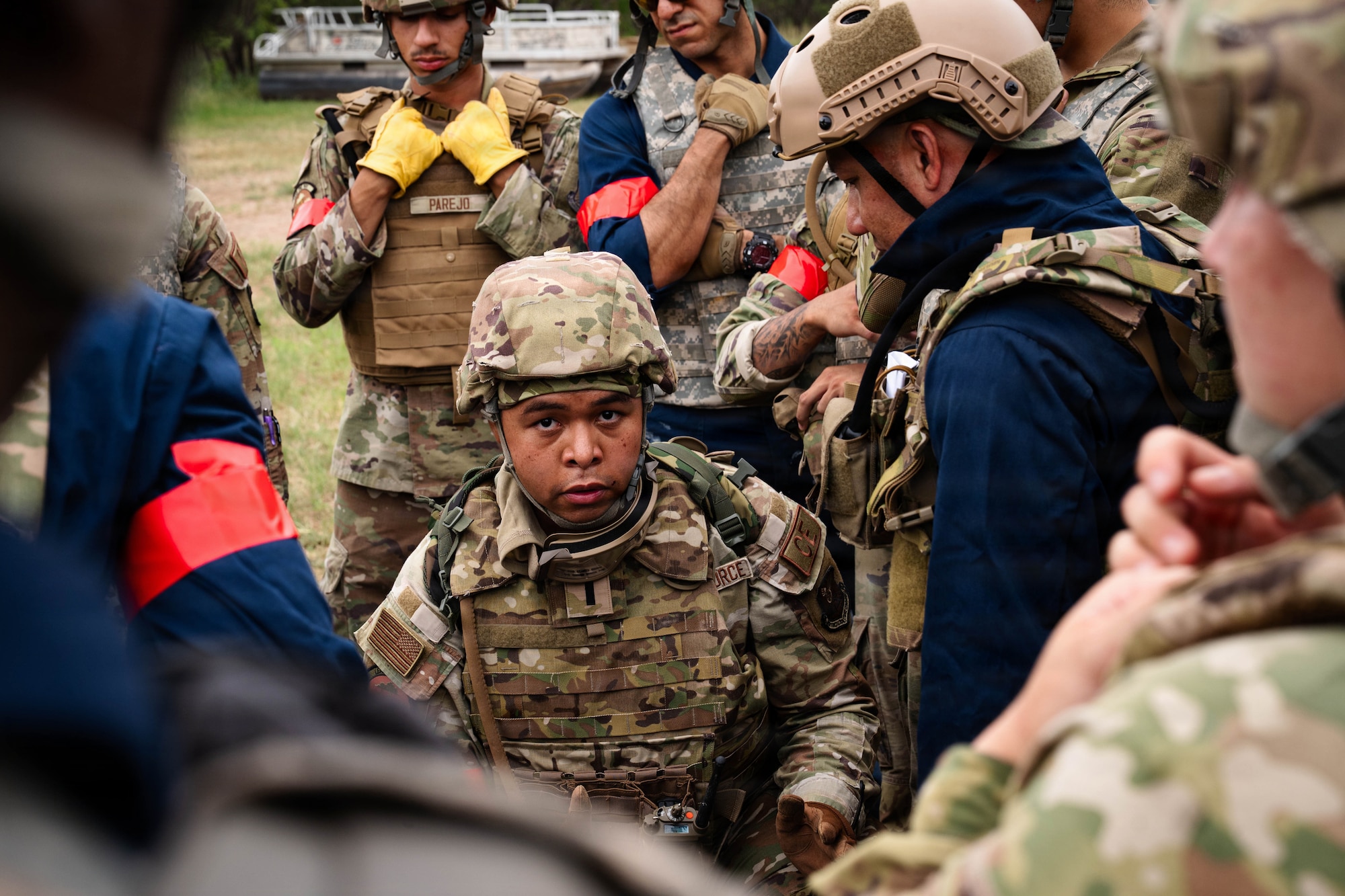 Airmen participate in a field exercise and play capture the flag outside in a wooded area