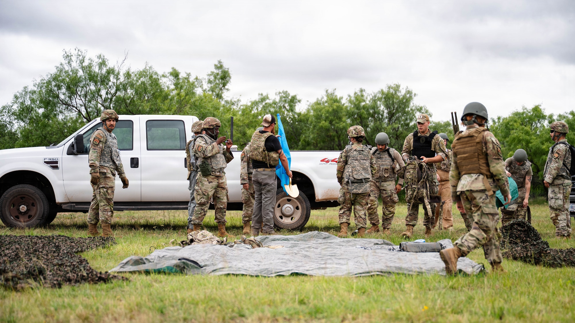 Airmen participate in a field exercise and play capture the flag outside in a wooded area