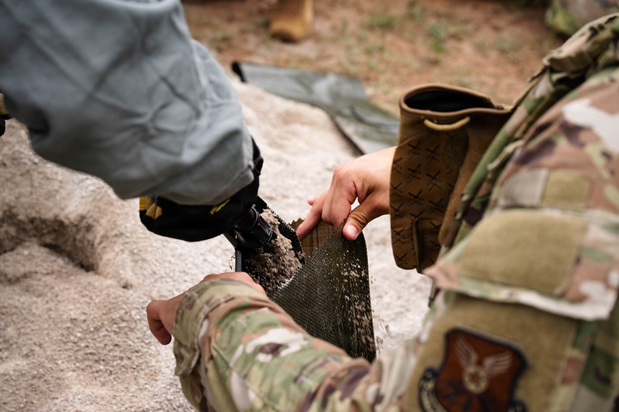 Airmen participate in a field exercise and play capture the flag outside in a wooded area