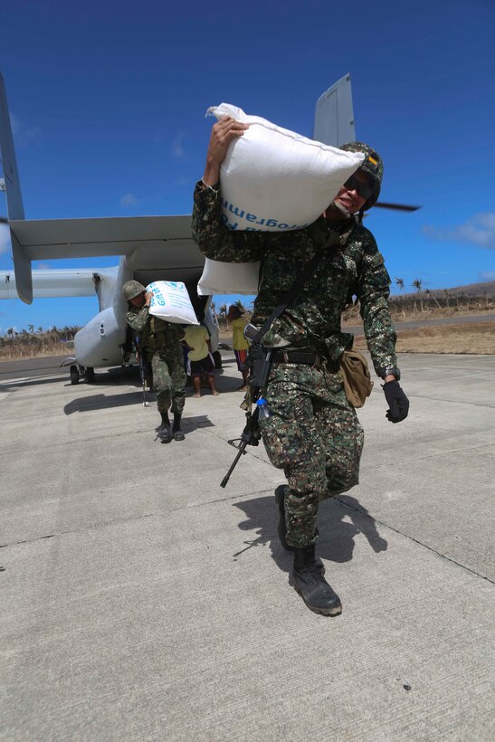 Philippine Marines unload bags of rice off of an MV-22B Osprey tiltrotor aircraft from Marine Medium Tiltrotor Squadron 265, 31st Marine Expeditionary Unit during humanitarian assistance relief operations here, Nov. 25.  Elements of the 31st MEU are deployed at the request of the government of the Philippines and in coordination with the U.S. Agency for International Development. The 31st MEU is ideally suited for humanitarian assistance operations, with aviation and amphibious platforms capable of rapidly delivering relief supplies, medical assistance, and transportation and engineer equipment to affected areas that are inaccessible by other means. U.S. forces have been delivering relief supplies provided by USAID since the start of Operation Damayan. (U.S. Marine Corps photo by PFC Brian Bekkala/Released)
