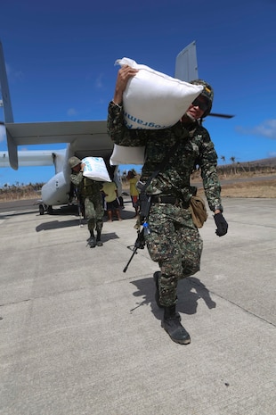 Philippine Marines unload bags of rice off of an MV-22B Osprey tiltrotor aircraft from Marine Medium Tiltrotor Squadron 265, 31st Marine Expeditionary Unit during humanitarian assistance relief operations here, Nov. 25.  Elements of the 31st MEU are deployed at the request of the government of the Philippines and in coordination with the U.S. Agency for International Development. The 31st MEU is ideally suited for humanitarian assistance operations, with aviation and amphibious platforms capable of rapidly delivering relief supplies, medical assistance, and transportation and engineer equipment to affected areas that are inaccessible by other means. U.S. forces have been delivering relief supplies provided by USAID since the start of Operation Damayan. (U.S. Marine Corps photo by PFC Brian Bekkala/Released)