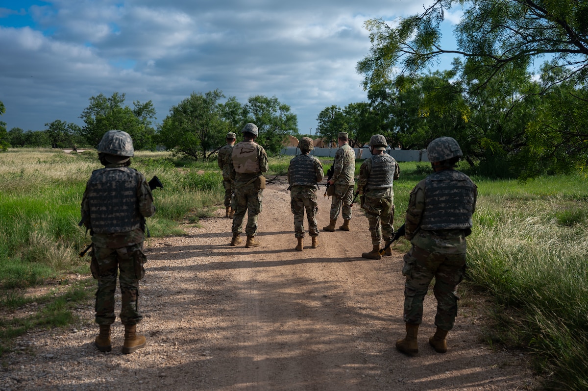 Airmen assigned to the 17th Training Wing scan a route for unexploded ordnance during the inaugural Ready Airman Training Day at Goodfellow Air Force Base, Texas, Aug. 8, 2026. The scenario required participants to identify and report simulated UXO while moving through a designated area, replicating the split-second recognition and reporting demands Airmen face in deployed environments. (U.S. Air Force photo by Senior Airman James Salellas)
