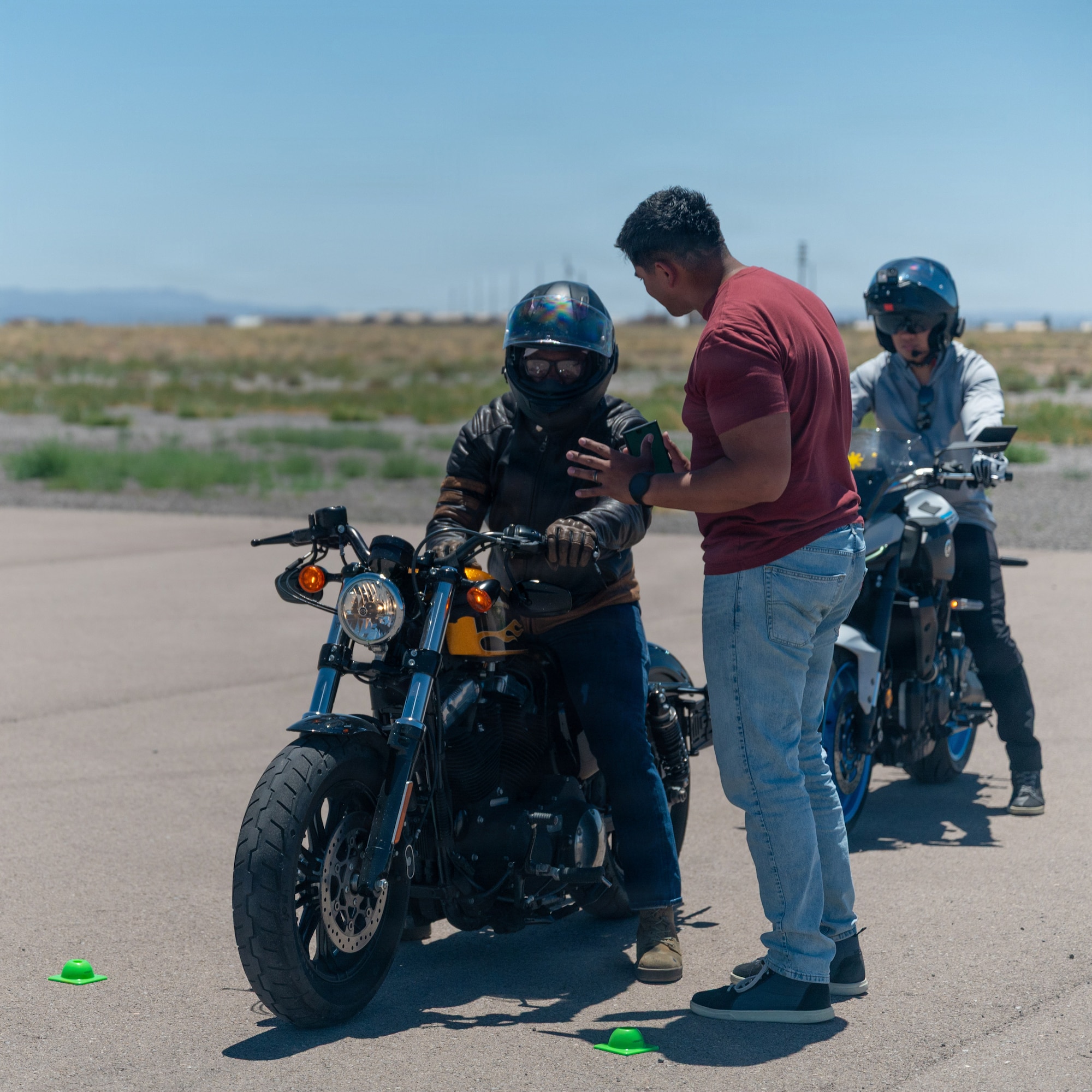 U.S. Air Force Tech. Sgt. Daniel Muñoz, 49th Wing weapons safety manager, center, instructs a motorcycle rider at the Rider Mentorship Program at Holloman Air Force Base, New Mexico, May 19, 2026.