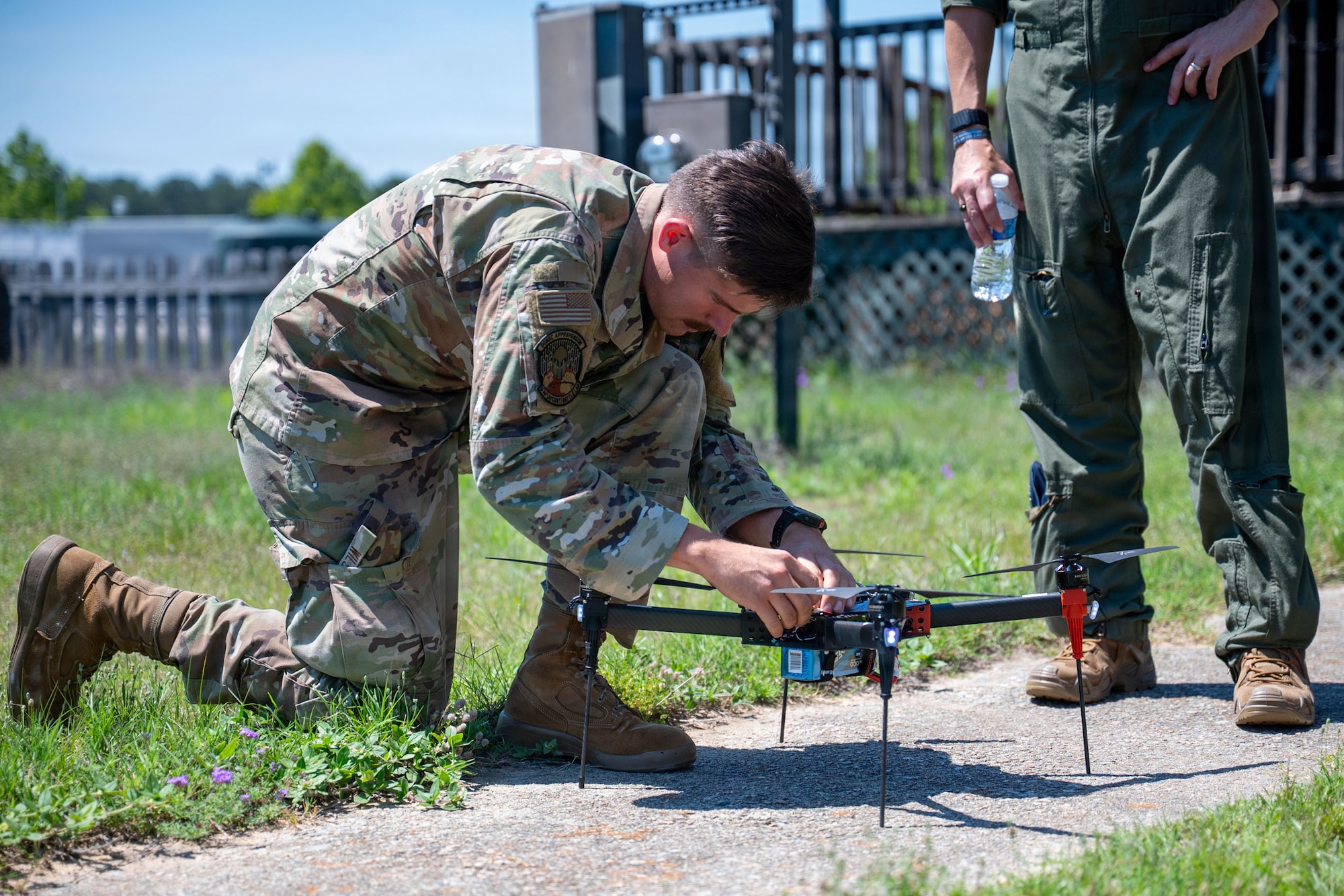 An Airman adjusts rotors on a drone