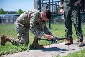 An Airman adjusts rotors on a drone