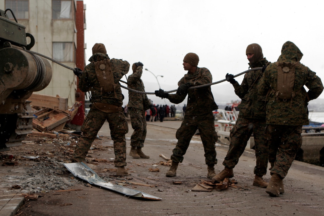 Marines with Battalion Landing Team 2nd Battalion, 5th Marines, 31st Marine Expeditionary Unit, pull a cable from the winch of a bulldozer, April 4. The Marines were in the process of tearing down a house damaged beyond repair, making it safer for the locals, and allowing more access to the port. As part of Operation Tomodachi, the 31st MEU is ready to support our Japanese partners and to provide assistance when called upon. (U.S. Marine Corps photo by Lance Cpl. Garry J. Welch/Released)