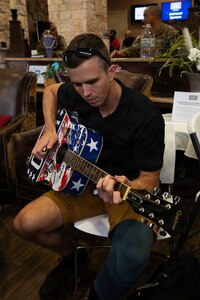 U.S. Army Capt. Eric Blake plays guitar at the welcome lunch hosted by the USO in anticipation of the 2026 Warrior Games