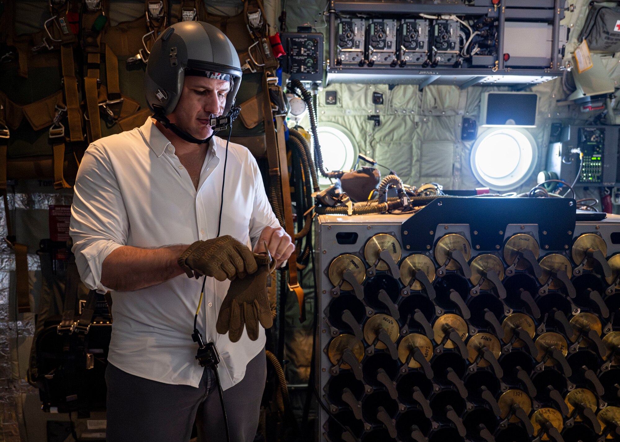 Derrick Anderson, Assistant Secretary of War for Special Operations and Low-Intensity Conflict, puts on gloves aboard a 1st Special Operations Wing AC-130J Ghostrider during a familiarization flight