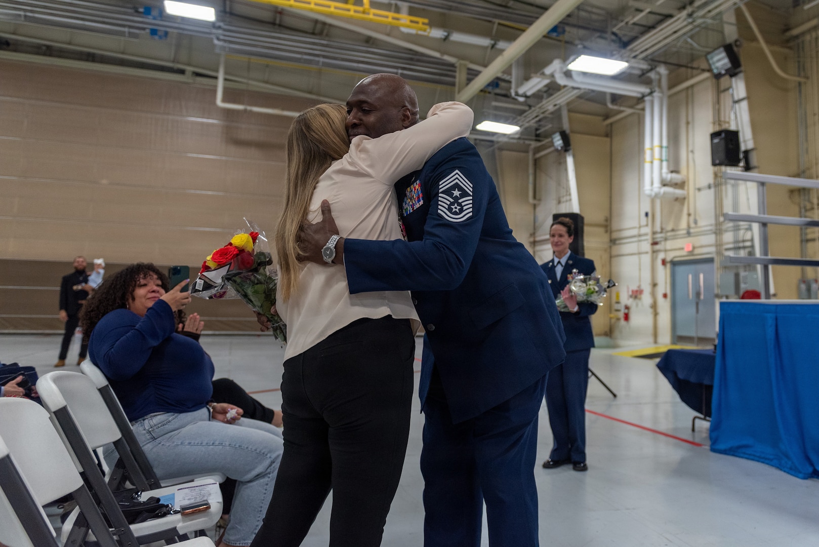 U.S. Air Force Chief Master Sgt. Marlon Burton, the command chief of the Illinois Air National Guard, gives flowers to his spouse during his retirement ceremony in Peoria, Illinois, May 3, 2026.