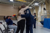 U.S. Air Force Chief Master Sgt. Marlon Burton, the command chief of the Illinois Air National Guard, gives flowers to his spouse during his retirement ceremony in Peoria, Illinois, May 3, 2026.
