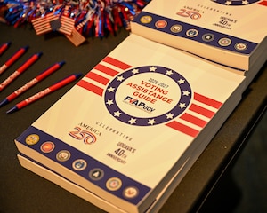 The FVAP voting assistance guide sits on the corner of the table that is decorated patriotically.