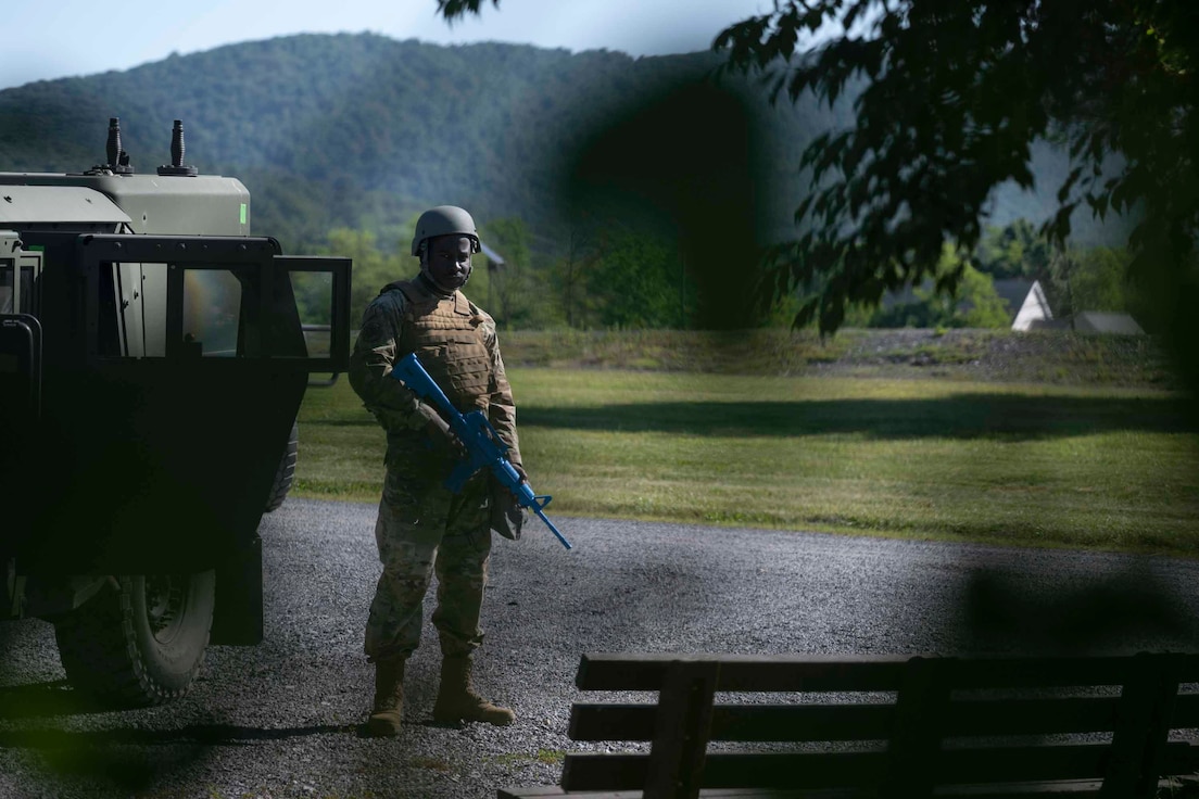 An Airman guards a humvee in tactical gear.