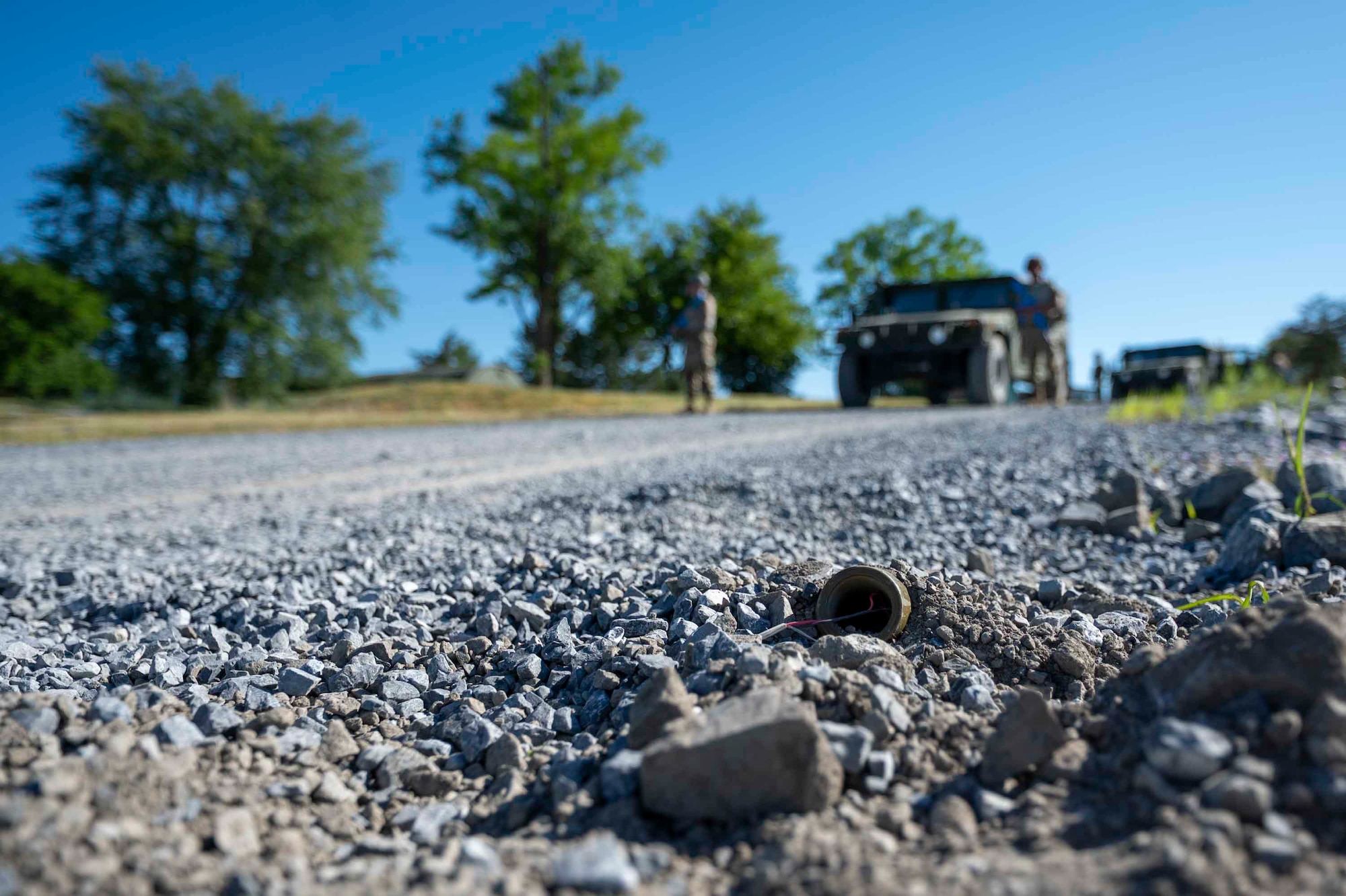 A mock improvised explosive device sits on a gravel road ahead of the 11th Civil Engineer Squadron’s convoy.