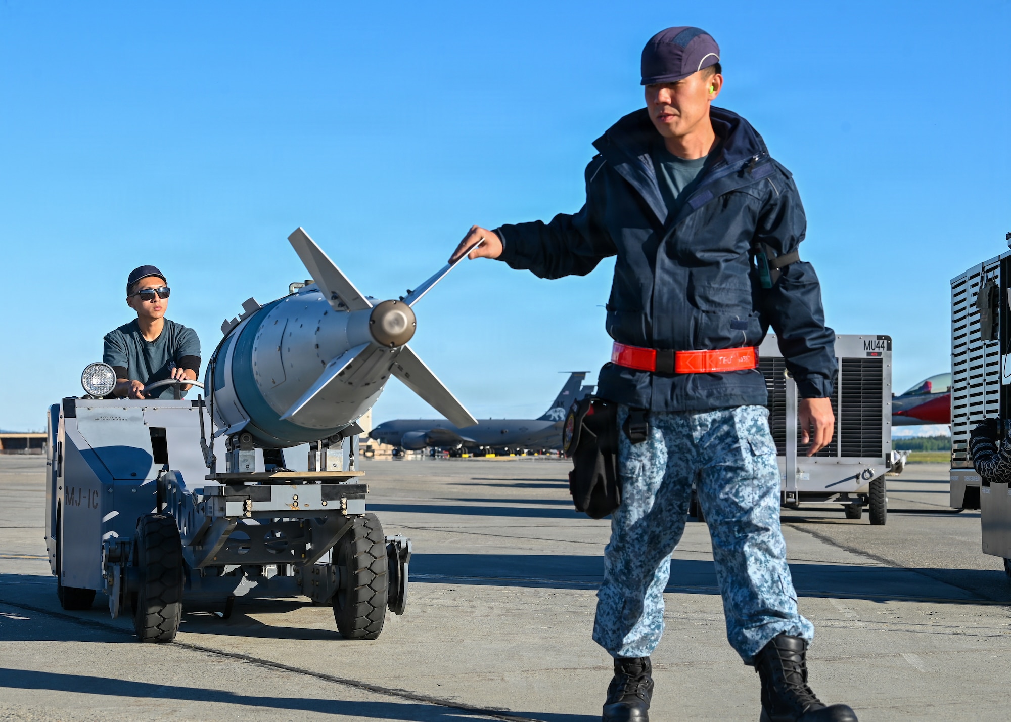 Republic of Singapore Air Force Military Expert 1 Travis Toh, left, and Military Expert 2 Terry Teo, 425th Fighter Squadron maintainers, transport a BDU-50 inert practice bomb on the flight line at Eielson Air Force Base, Alaska, during RED FLAG-Alask 26-2, June 3, 2026.