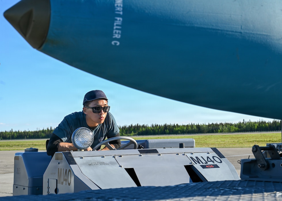 Republic of Singapore Air Force Military Expert 1 Travis Toh, a 425th Fighter Squadron maintainer, observes a BDU-50 inert practice bomb as he prepares to transport it on the flight line at Eielson Air Force Base, Alaska, during RED FLAG-Alask 26-2, June 3, 2026.