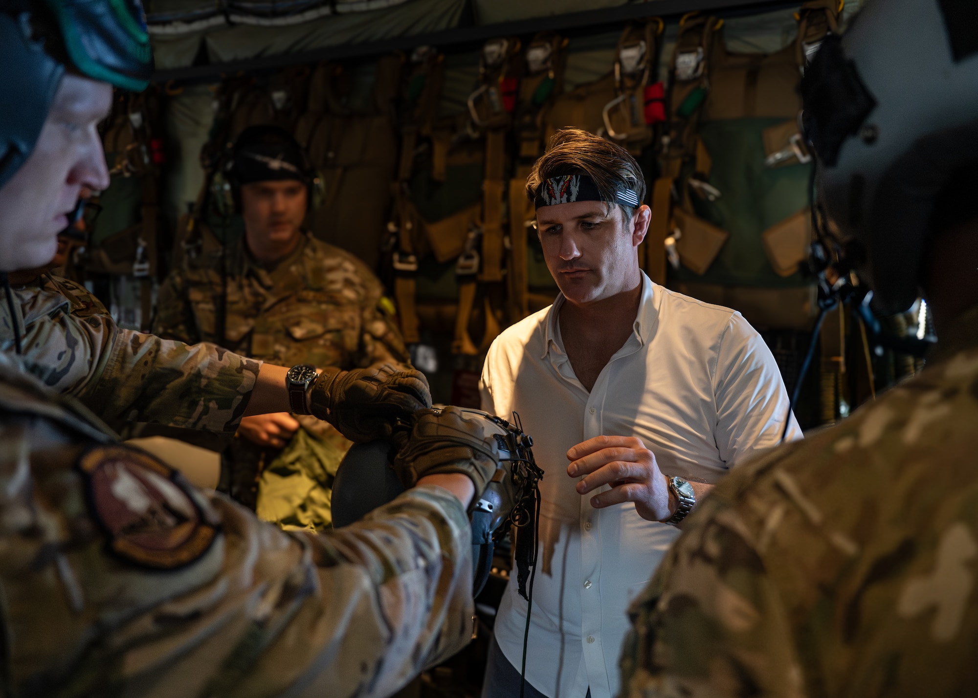 A special missions aviator assigned to the 1st Special Operations Wing hands Derrick Anderson, Assistant Secretary of War for Special Operations and Low-Intensity Conflict, a helmet before a familiarization flight