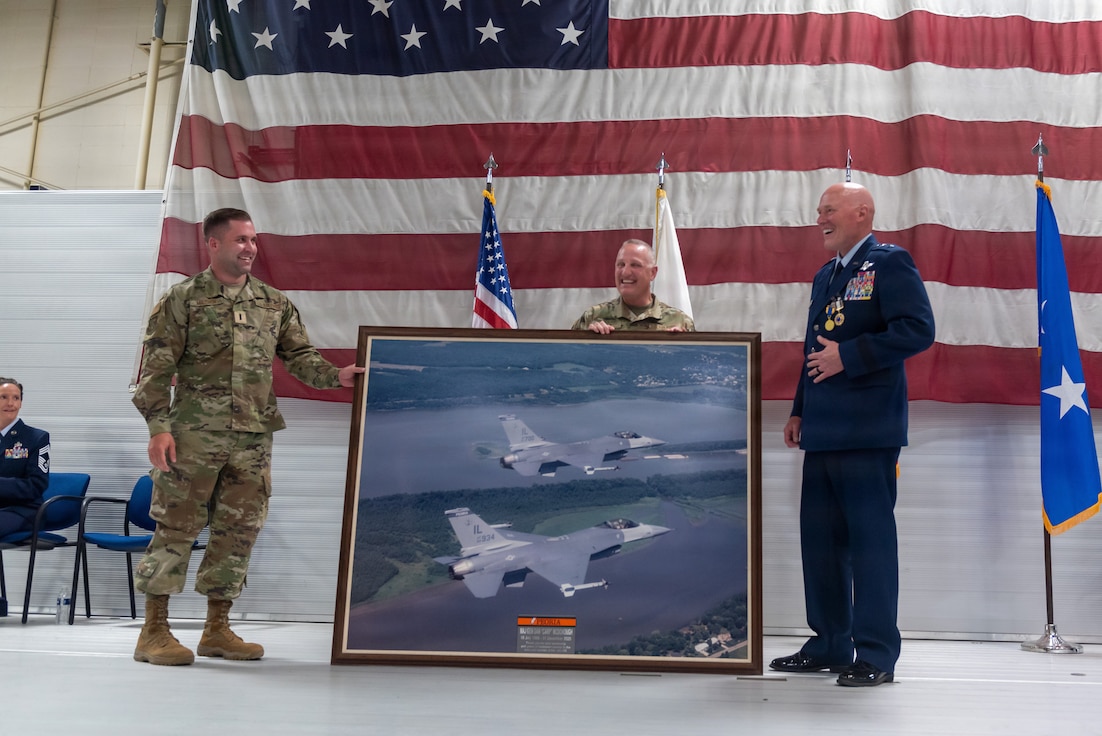 U.S. Air Force Col. Robert Reed, center, presents a framed photograph of F-16 Fighting Falcon aircraft to Maj. Gen. Daniel R. McDonough during a retirement ceremony at the 182nd Airlift Wing in Peoria, Illinois, June 6, 2026.