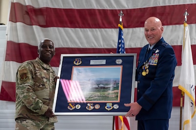 U.S. Air Force Brig. Gen. Kevin Jacobs, left, presents a framed aerial photograph to Maj. Gen. Daniel R. McDonough during a retirement ceremony at the 182nd Airlift Wing in Peoria, Illinois.
