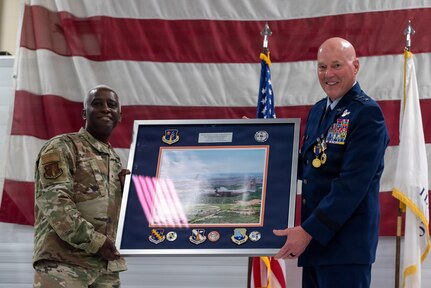 U.S. Air Force Brig. Gen. Kevin Jacobs, left, presents a framed aerial photograph to Maj. Gen. Daniel R. McDonough during a retirement ceremony at the 182nd Airlift Wing in Peoria, Illinois.