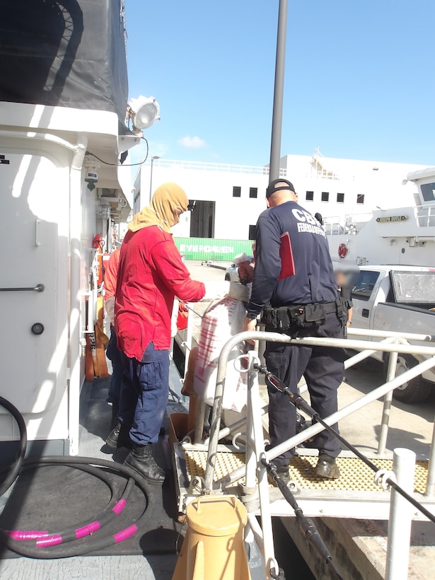 Coast Guard Cutter Isaac Mayo crewmembers and Homeland Security Task Force - San Juan Region law enforcement partners transfer custody of a stowaway and seized a weapon and nine bales of cocaine, with an estimated wholesale value of $4.8 million, at Coast Guard Base San Juan, June 10, 2026. The apprehension and seizure occurred during a Coast Guard boarding of the Crimson Clover Barge off Arecibo, Puerto Rico. This interdiction is part of Homeland Security Task Force – San Juan Region efforts to combat human smuggling, drug trafficking, and deter unlawful maritime migration. (U.S. Coast Guard photo)