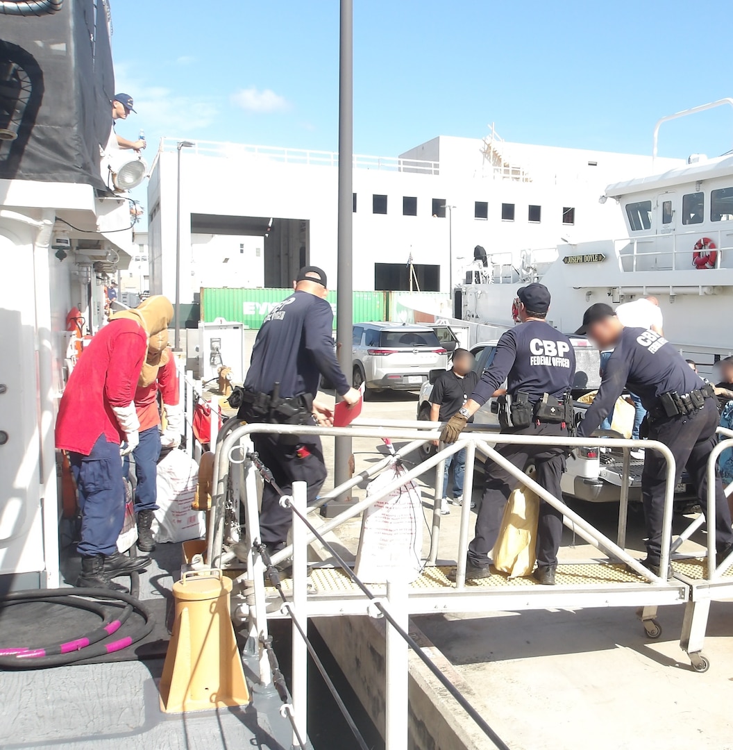 Coast Guard Cutter Isaac Mayo crewmembers and Homeland Security Task Force - San Juan Region law enforcement partners transfer custody of a stowaway and seized a weapon and nine bales of cocaine, with an estimated wholesale value of $4.8 million, at Coast Guard Base San Juan, June 10, 2026. The apprehension and seizure occurred during a Coast Guard boarding of the Crimson Clover Barge off Arecibo, Puerto Rico. This interdiction is part of Homeland Security Task Force – San Juan Region efforts to combat human smuggling, drug trafficking, and deter unlawful maritime migration. (U.S. Coast Guard photo)