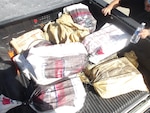 Coast Guard Cutter Isaac Mayo crewmembers and Homeland Security Task Force - San Juan Region law enforcement partners transfer custody of a stowaway and seized a weapon and nine bales of cocaine, with an estimated wholesale value of $4.8 million, at Coast Guard Base San Juan, June 10, 2026. The apprehension and seizure occurred during a Coast Guard boarding of the Crimson Clover Barge off Arecibo, Puerto Rico. This interdiction is part of Homeland Security Task Force – San Juan Region efforts to combat human smuggling, drug trafficking, and deter unlawful maritime migration. (U.S. Coast Guard photo)