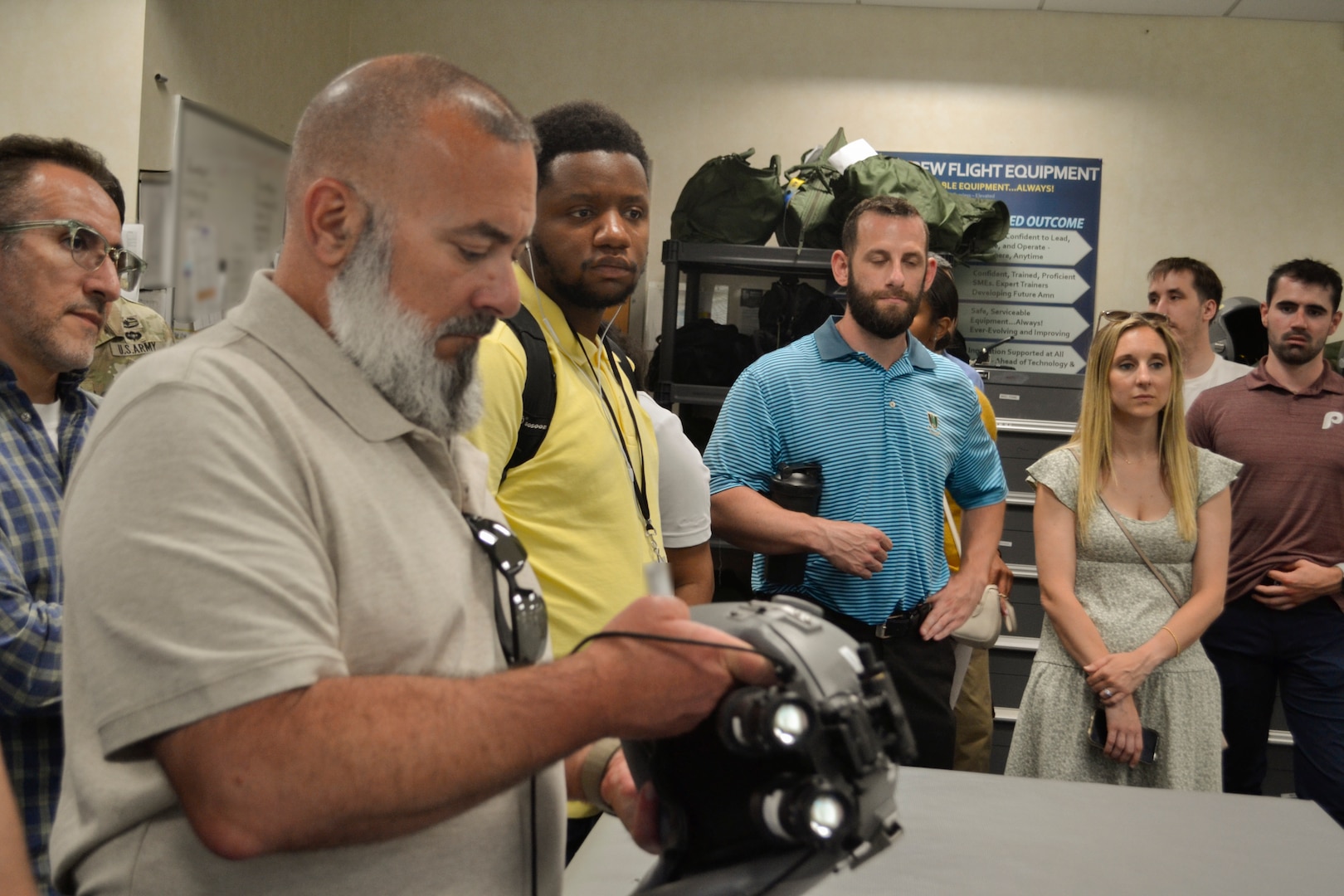 An employee from Defense Logistics Agency Troop Support examines the visor and communications system of a flight helmet at the 108th Wing's aircrew flight equipment facility. The interactive tour allowed DLA Troop Support Academy participants to inspect the specialized gear maintained by the New Jersey Air National Guard, highlighting the critical standards required in the strategic acquisition process.