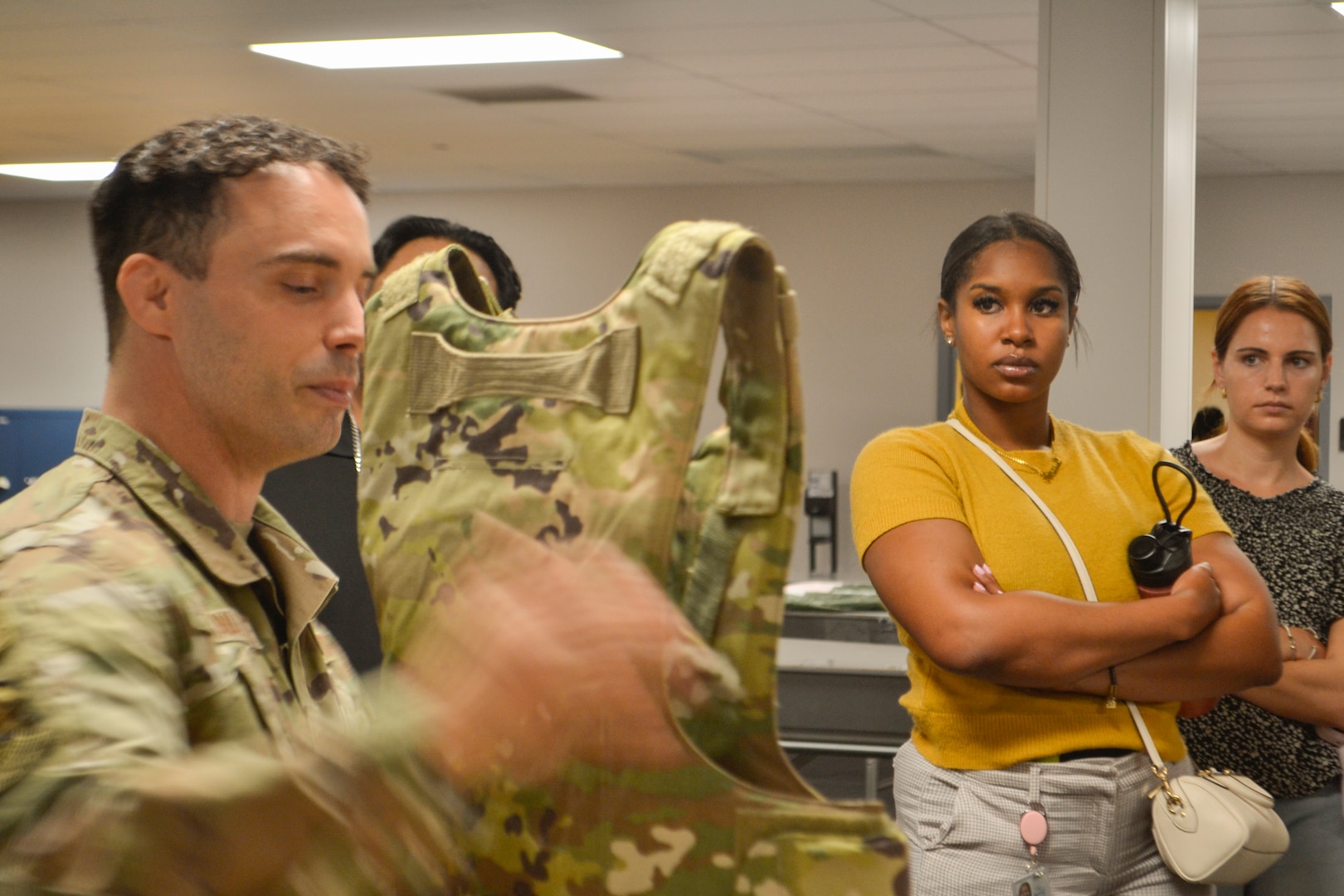 A New Jersey Air National Guard airman from the 108th Wing points out the integrated components of a tactical bulletproof vest to Defense Logistics Agency Troop Support Academy participants. The demonstration highlighted the direct link between the clothing and textile contracts managed by DLA in Philadelphia and the physical protection of service members on the front lines.