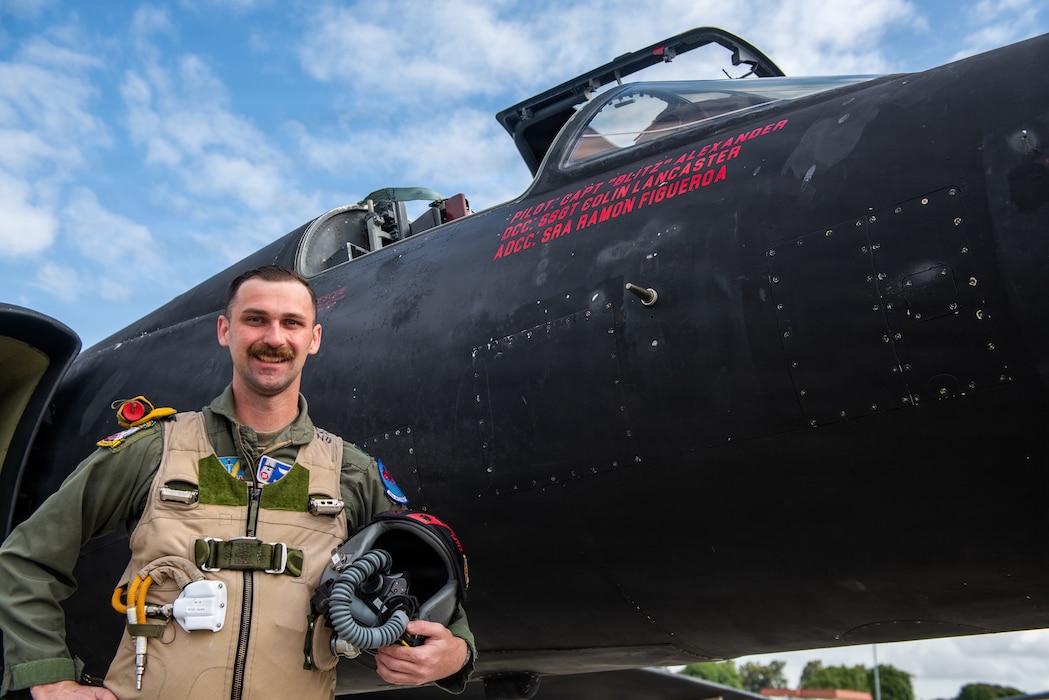 Pilot poses for photo in front of aircraft