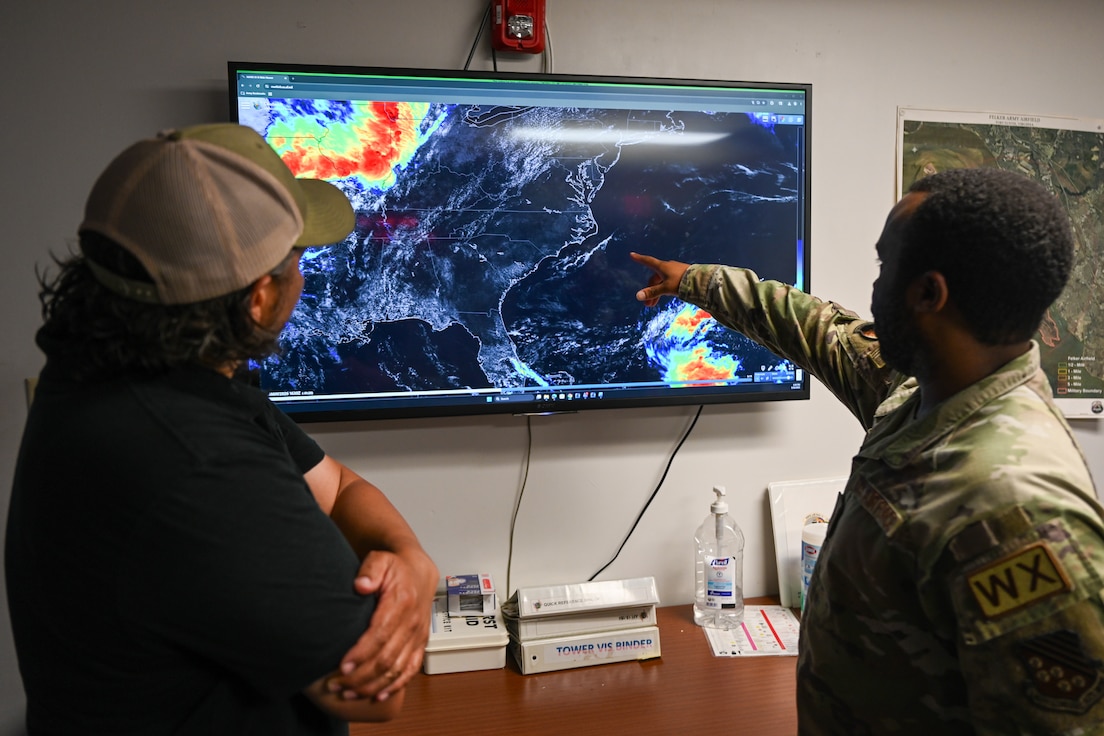 Airman points at tv next to civilian. (U.S. Air Force photo by Airman 1st Class Donnell Ramsey)