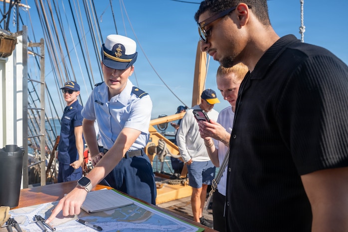 A photo of two people conversing aboard the U.S. Coast Guard Cutter Eagle.