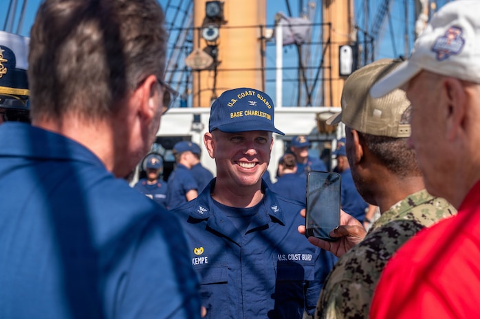 A photo of men conversing aboard the U.S. Coast Guard Cutter Eagle