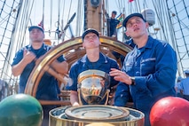 A photo of Coast Guardsmen steering the Coast Guard Cutter Eagle.
