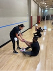Linda Pai, Team Army sitting volleyball coach, assists Sgt. Elon Smith during sitting volleyball training at Team Army group sports camp ahead of the 2026 Warrior Games in San Antonio, Texas.
