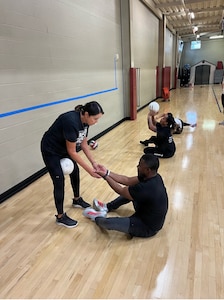 Linda Pai, Team Army sitting volleyball coach, assists Sgt. Elon Smith during sitting volleyball training at Team Army group sports camp ahead of the 2026 Warrior Games in San Antonio, Texas.