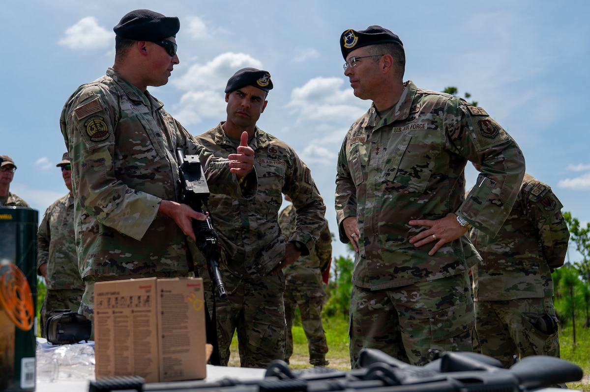 U.S. Air Force Master Sgt. Jonathan Calo, 325th Security Forces Squadron logistics and readiness superintendent, and Senior Master Sgt. Reginald Walters, 325th SFS future operations superintendent, explain the capabilities of a new counter-drone weapon system to Maj. Gen. Thomas P. Sherman, Air Force Installation and Mission Support Center commander, at Tyndall Air Force Base, Florida, June 3, 2026. The training highlighted the 325th SFS's enhanced readiness and its ability to equip Airmen with the skills needed to counter modern airborne threats. (U.S. Air Force photo by Airman 1st Class Rosario Garcia)