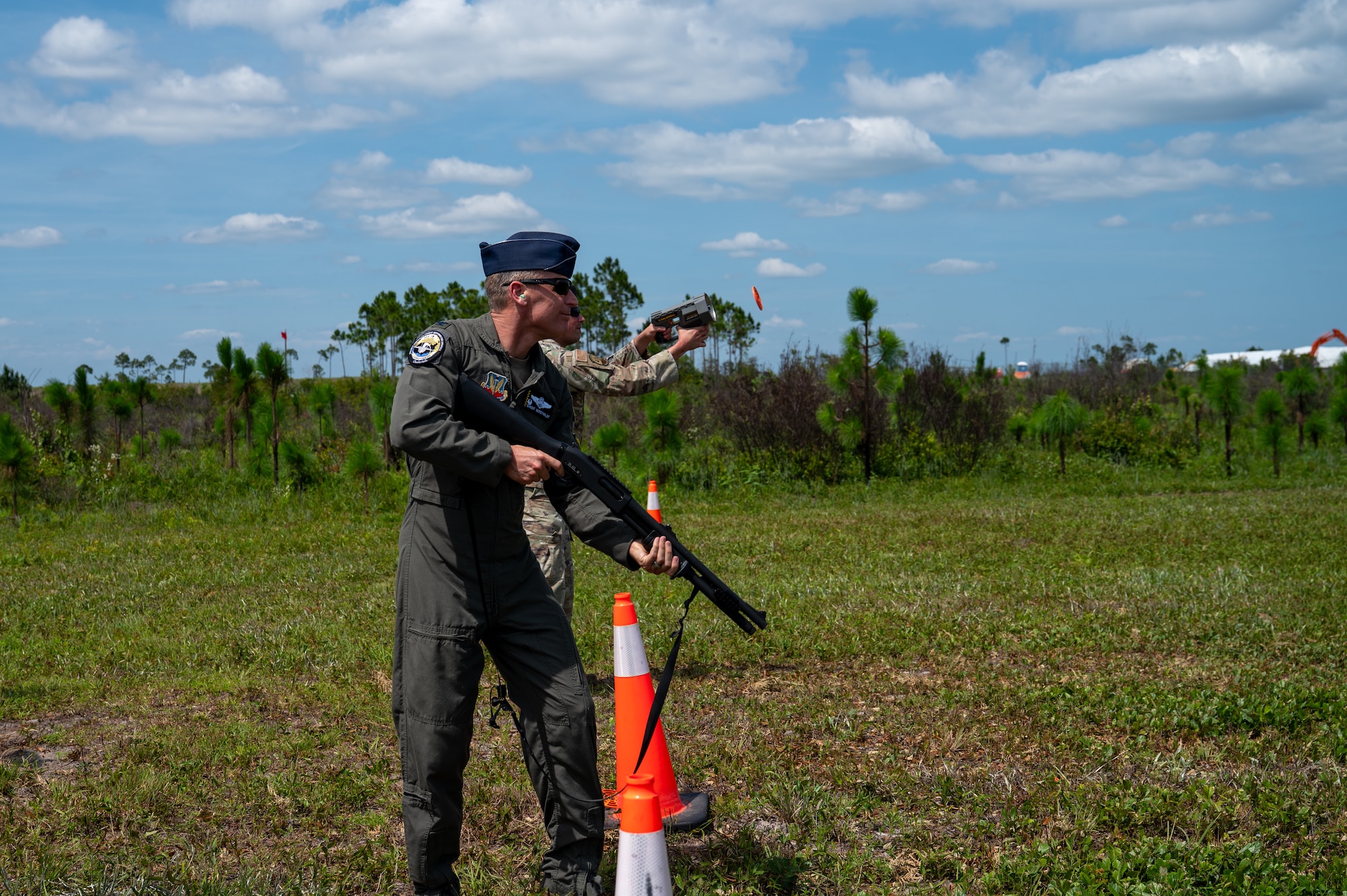 U.S. Air Force Col. Christian Bergtholdt, 325th Fighter Wing commander, aims an M870 shotgun as Master Sgt. Jonathan Calo, 325th Security Forces Squadron logistics and readiness superintendent, launches a simulated aerial target at Tyndall Air Force Base, Florida, June 3, 2026. Bergthold participated in the live-fire demonstration to gain a firsthand perspective on the new counter-small unmanned aircraft systems capabilities his defenders are using to protect the installation. (U.S. Air Force photo by Airman 1st Class Rosario Garcia)