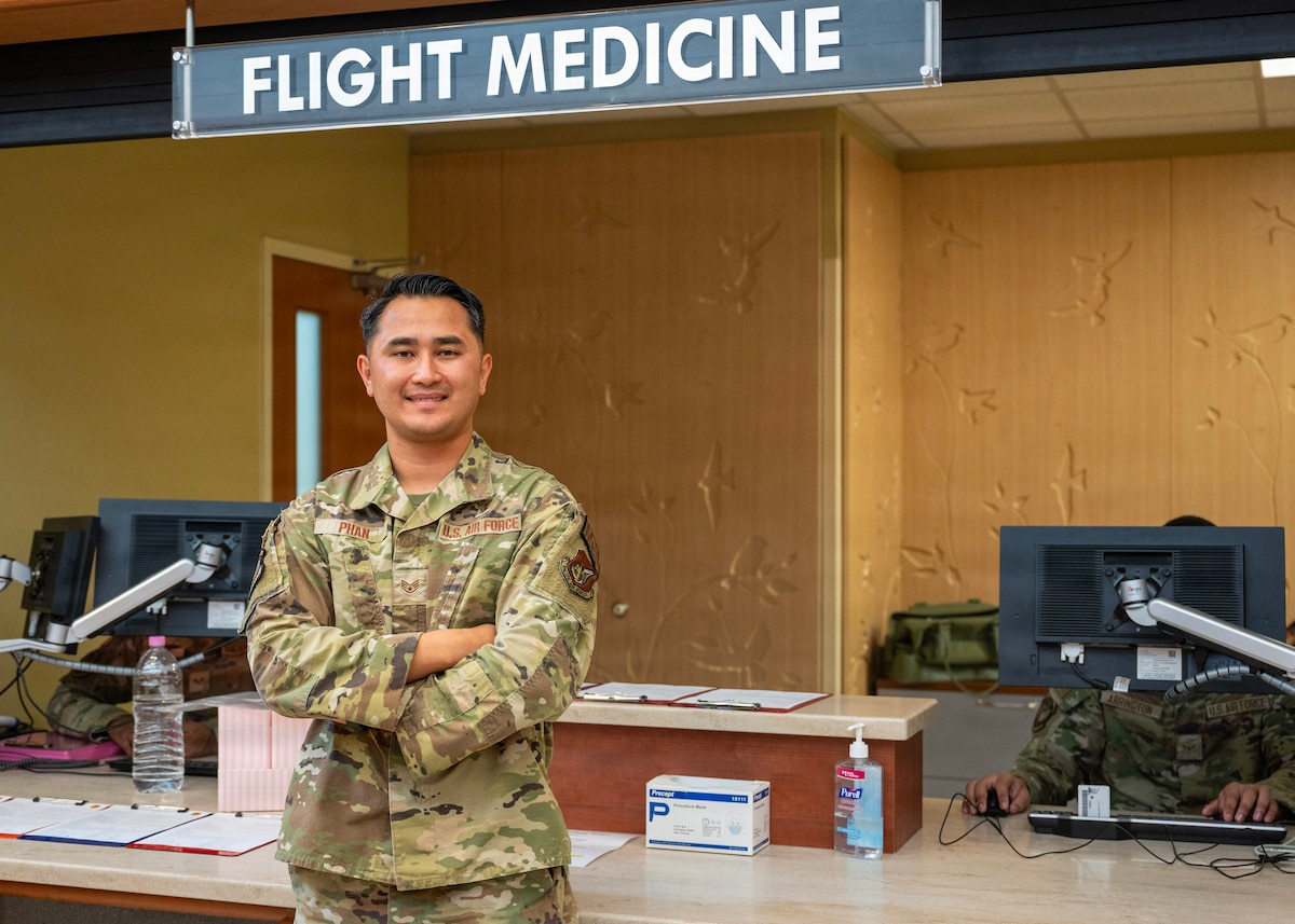 U.S. Air Force Staff Sgt. Tin Phan, 51st Operational Medical Readiness Squadron base operational medicine clinic noncommissioned officer in charge, poses for a photo in front of the flight medicine clinic, at Osan Air Base, Republic of Korea, June 10, 2026. Phan is trusted to oversee programs that directly support the medical readiness of Airmen assigned to Osan. His responsibilities include medical record reviews, deployment waivers, occupational health exams, and overseeing annual health assessments, ensuring military members remain ready to support the 51st Fighter Wing’s “Fight Tonight” mission. (U.S. Air Force photo by Staff Sgt. Sarah Williams)
