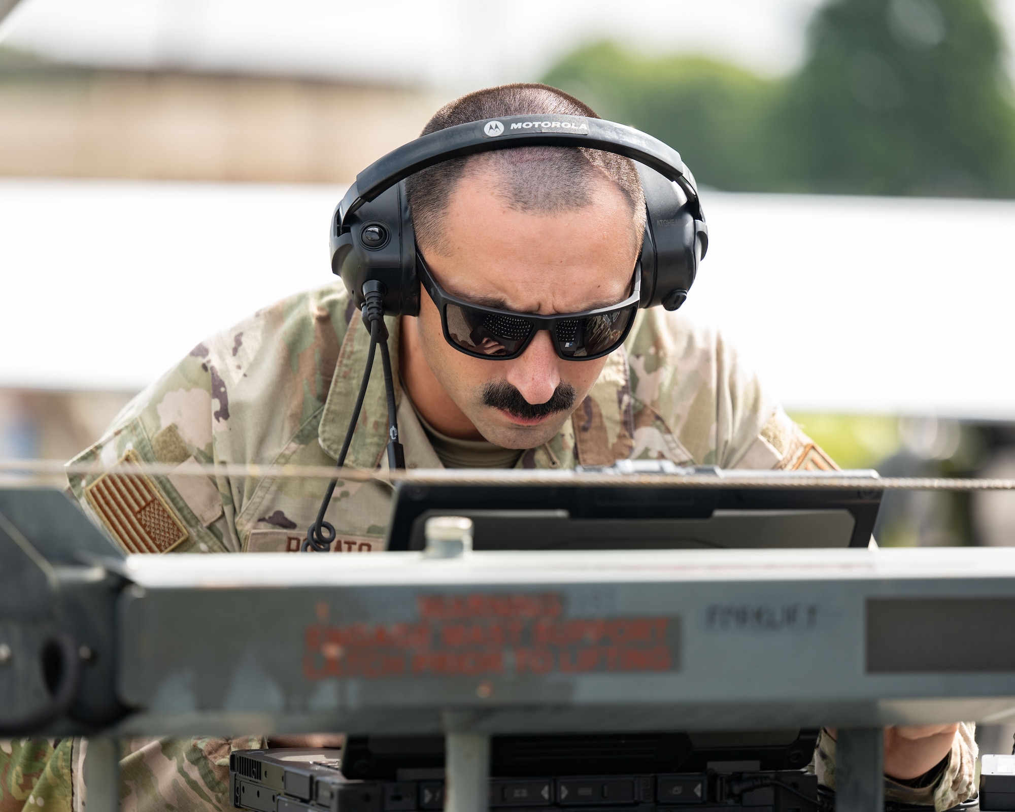 A servicemember looks at a laptop
