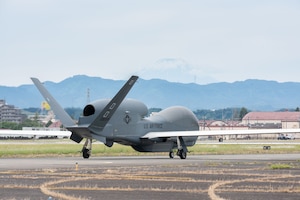 A military drone taxis along a flightline