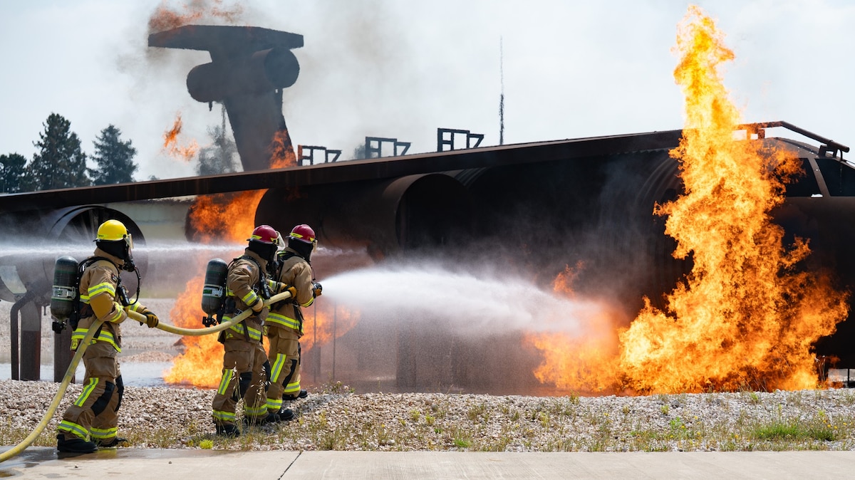 Three firefighters put out a fire.