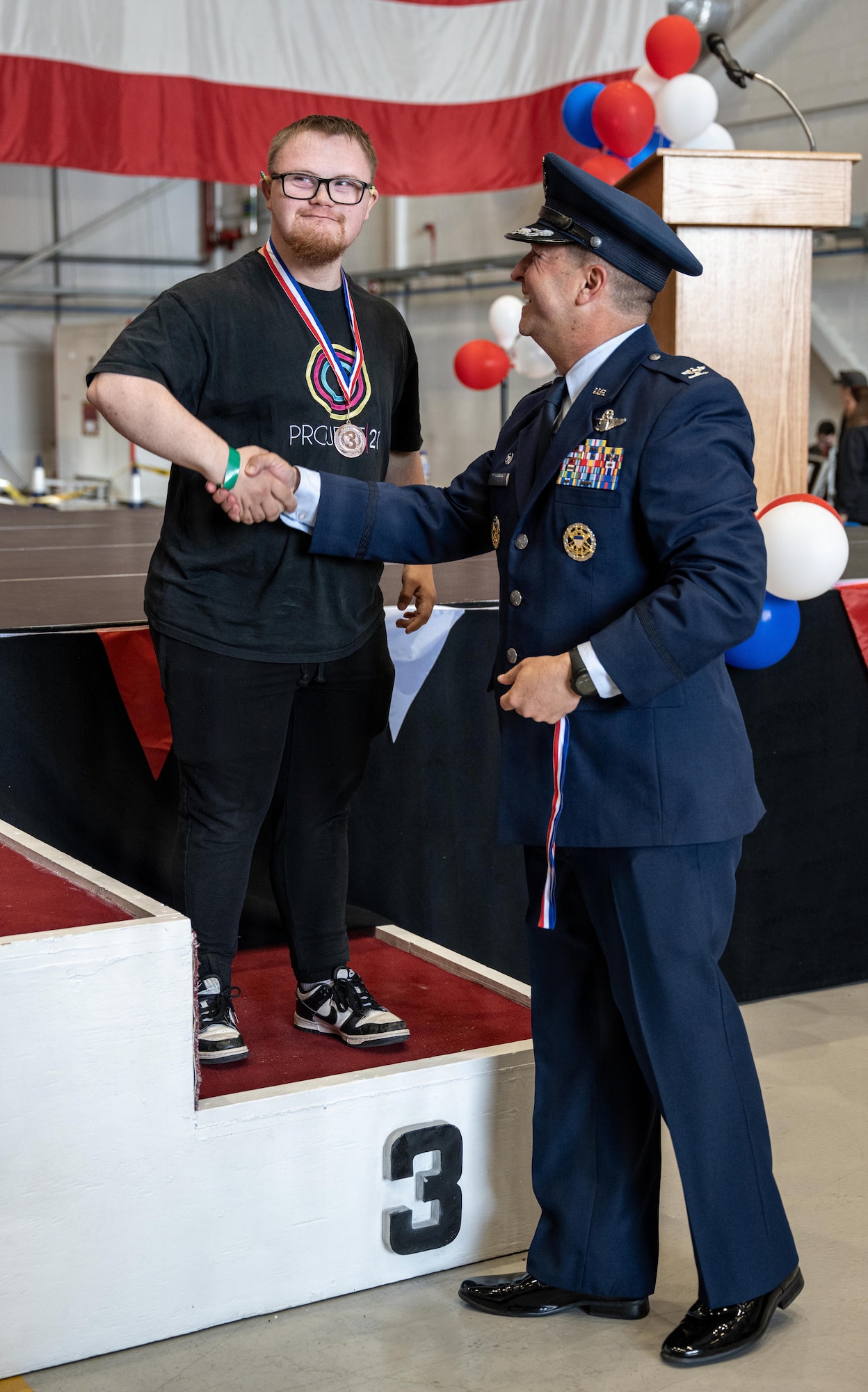 U.S. Air Force Col. Steven Byrum, right, 100th Air Refueling Wing commander, shakes hands with a winning athlete during Joan Mann Special Sports Day at RAF Mildenhall, England, June 4, 2026.