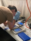 An end user loads a flow cell on a modified field sequencing device during Beholder’s Gaze training, Oct. 24, 2024. The event was attended by the U.S. Naval Research Laboratory and U.S. Army Combat Capabilities Development Command (DEVCOM) Chemical Biological Center military operators Far-Forward Advanced Sequencing Technology (F-FAST) team who conducted training and provided the technology/system. The effort brings sophisticated laboratory capability into austere environments, giving forward-deployed units the ability to detect and identify harmful pathogens in less than 30 minutes. Unlike conventional sequencing systems, Far-Forward Biological Sequencing (FFBS) is tailored for military personnel who may not have formal laboratory training. (U.S. Navy photo)