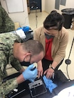 An end user loads a flow cell on a modified field sequencing device during Beholder’s Gaze training, Oct. 24, 2024. The event was attended by the U.S. Naval Research Laboratory and U.S. Army Combat Capabilities Development Command (DEVCOM) Chemical Biological Center military operators Far-Forward Advanced Sequencing Technology (F-FAST) team who conducted training and provided the technology/system. The effort brings sophisticated laboratory capability into austere environments, giving forward-deployed units the ability to detect and identify harmful pathogens in less than 30 minutes. Unlike conventional sequencing systems, Far-Forward Biological Sequencing (FFBS) is tailored for military personnel who may not have formal laboratory training. (U.S. Navy photo)