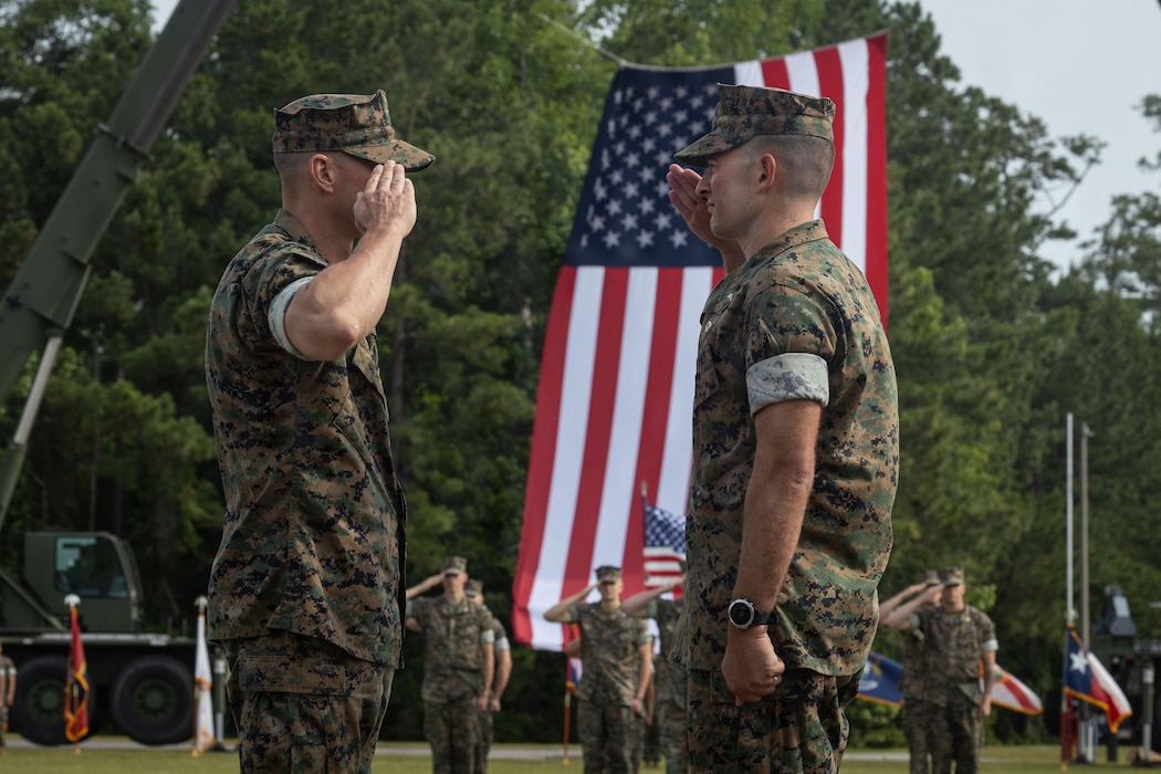 U.S. Marine Corps Lt. Col. Chad Phillips, right, the outgoing commanding officer of Headquarters and Service Battalion, 2nd Marine Logistics Group, and Lt. Col. Dustin Scott, the incoming commanding officer of Headquarters and Service Battalion, 2nd MLG, salute during a change of command ceremony at Marine Corps Base Camp Lejeune, North Carolina, June 10, 2026. The change of command ceremony is a time-honored tradition which formally signifies the transfer of command and entails the total accountability, authority and responsibility from one individual to another. Phillips is a native of Minnesota. Scott is a native of Florida. (U.S. Marine Corps photo by Lance Cpl. Isabelle Veillette)