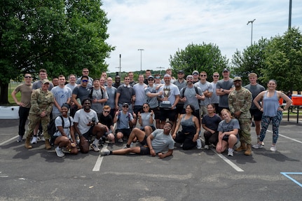 The 794th Communications Squadron gathers with Joint Base Anacostia-Bolling leadership after winning the base sports day trophy at JBAB, Washington, D.C., June 9, 2026. The annual event, which included a Humvee push, pickleball, tire flip, 3v3 basketball, wall climbing, tug-of-war and volleyball, fostered teamwork, camaraderie, physical fitness and friendly competition. (U.S. Air Force photo by Hayden Hallman)