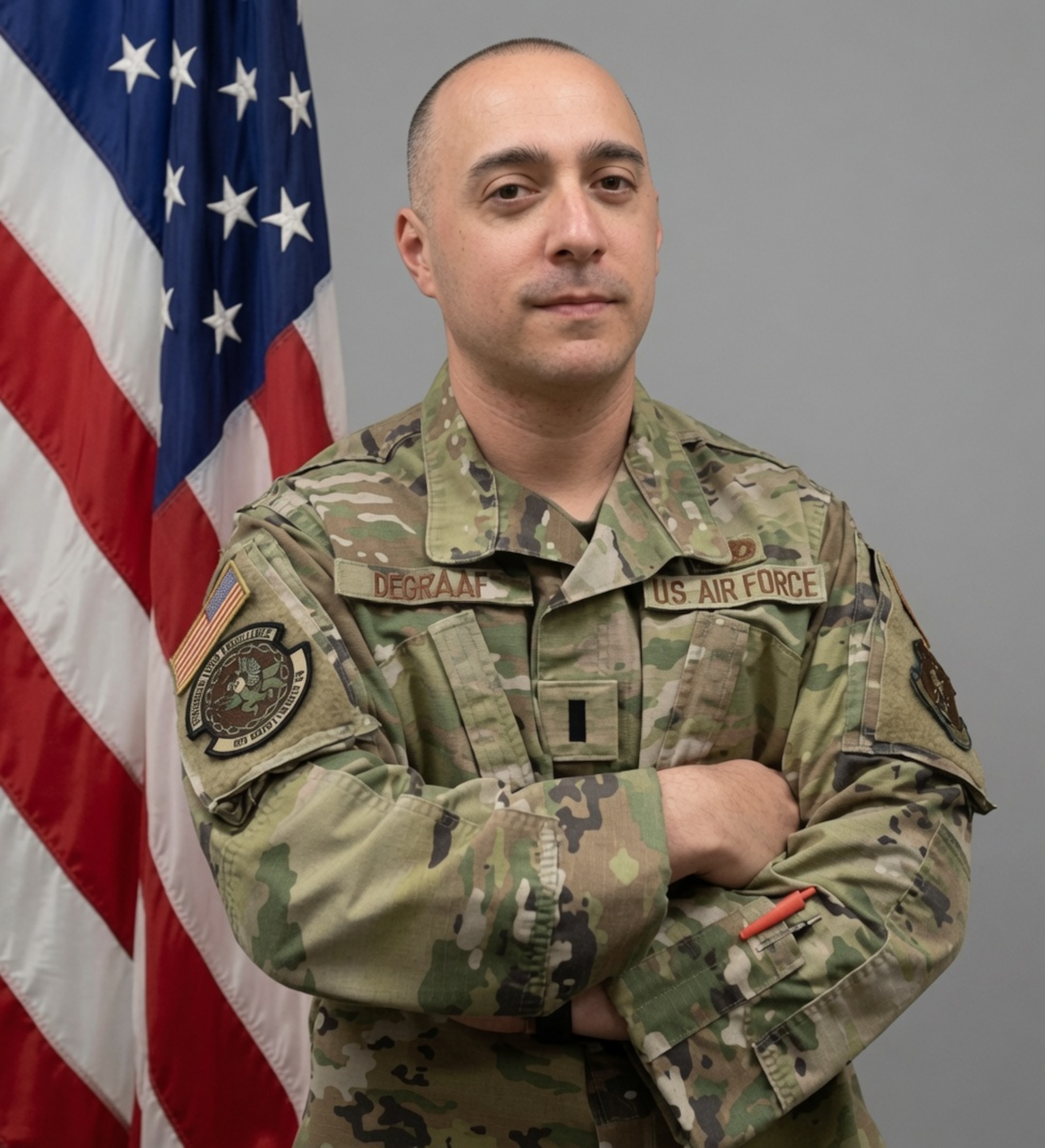 Lt. DeGraaf poses for photo in front of flag.