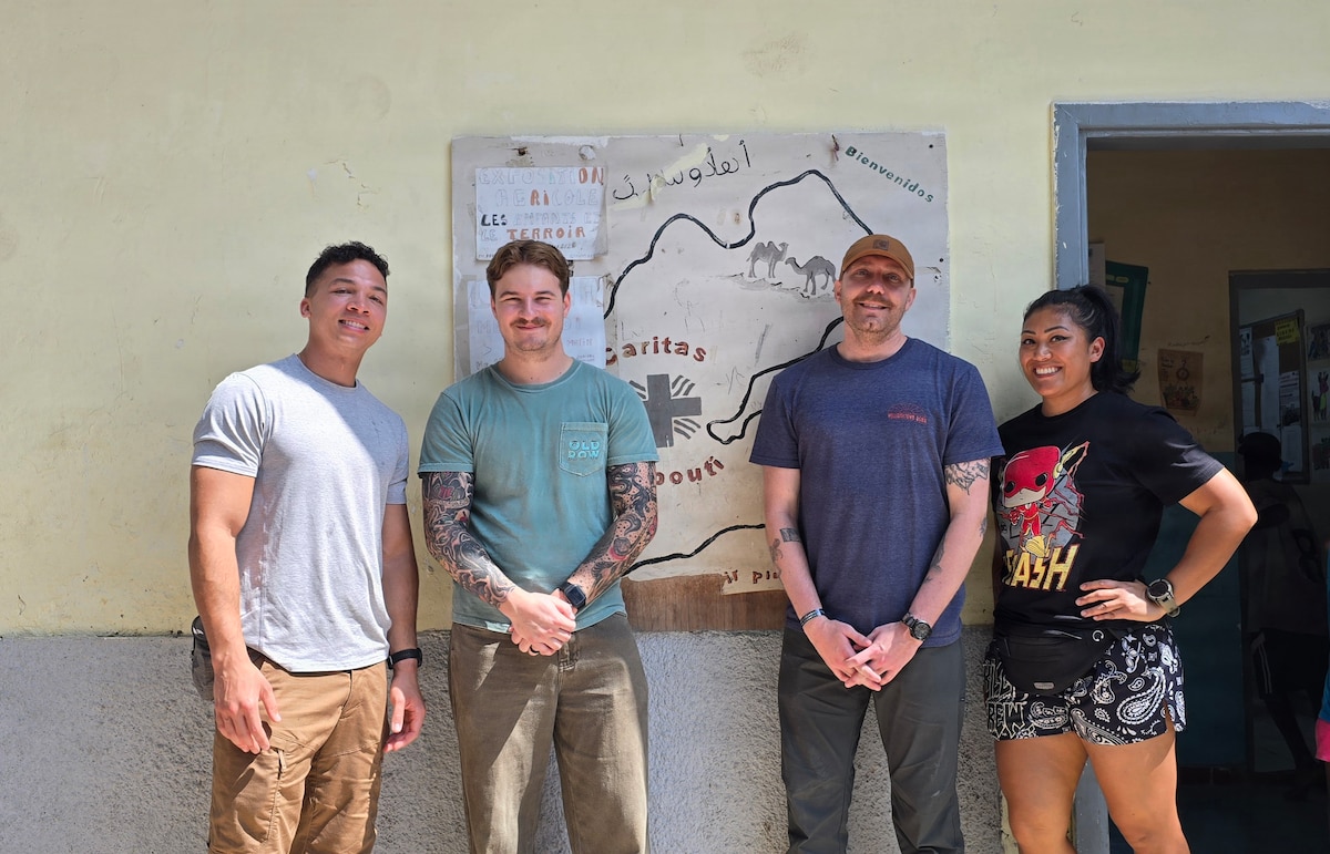 Air National Guardsmen take a photo with locals while volunteering at a orphanage during their deployment in Djibouti, Feb. 21. Members of the 130th Airlift Wing set up a medical clinic to assist with wound care for the local populace.