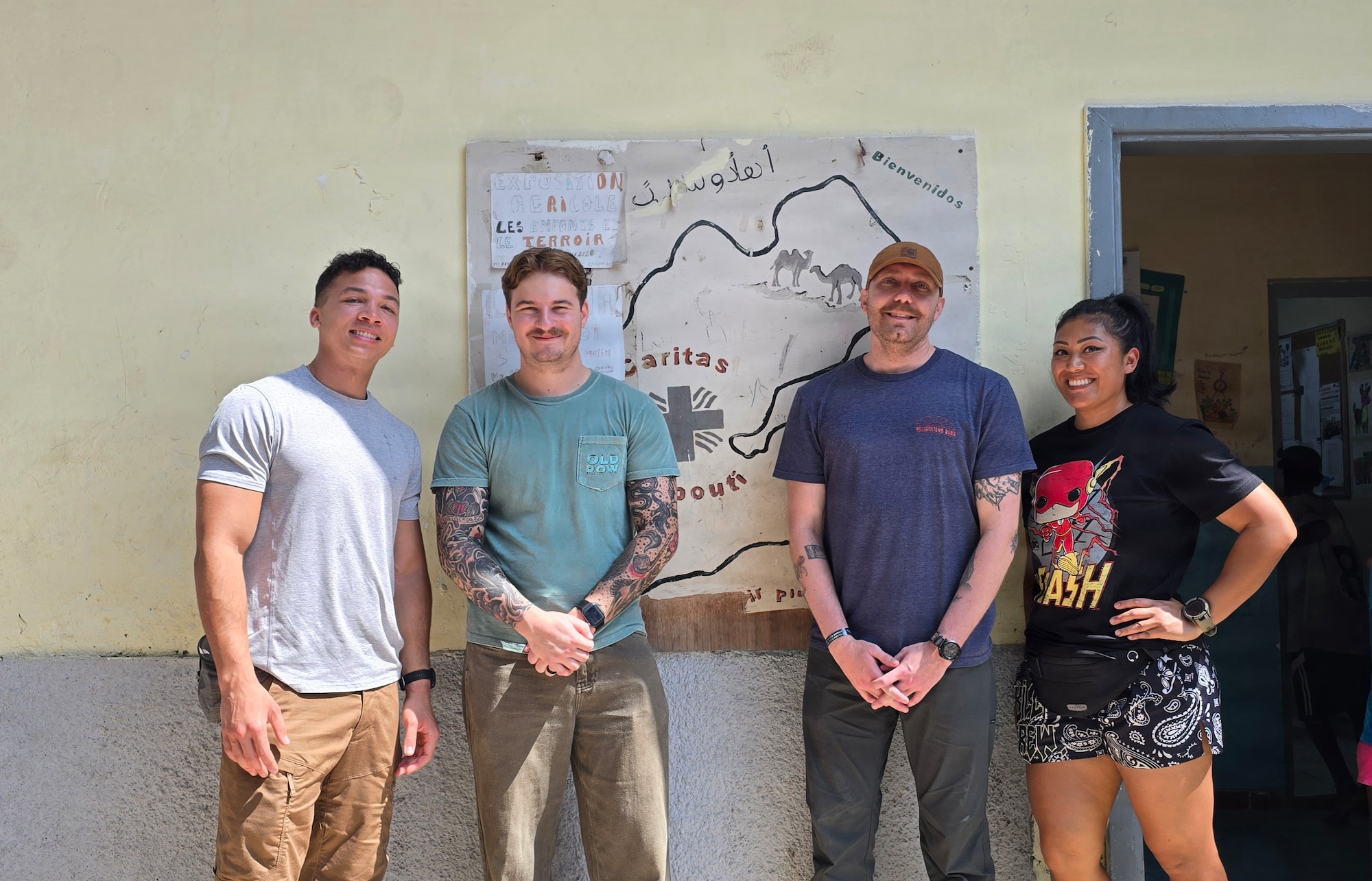 Air National Guardsmen take a photo with locals while volunteering at a orphanage during their deployment in Djibouti, Feb. 21. Members of the 130th Airlift Wing set up a medical clinic to assist with wound care for the local populace.